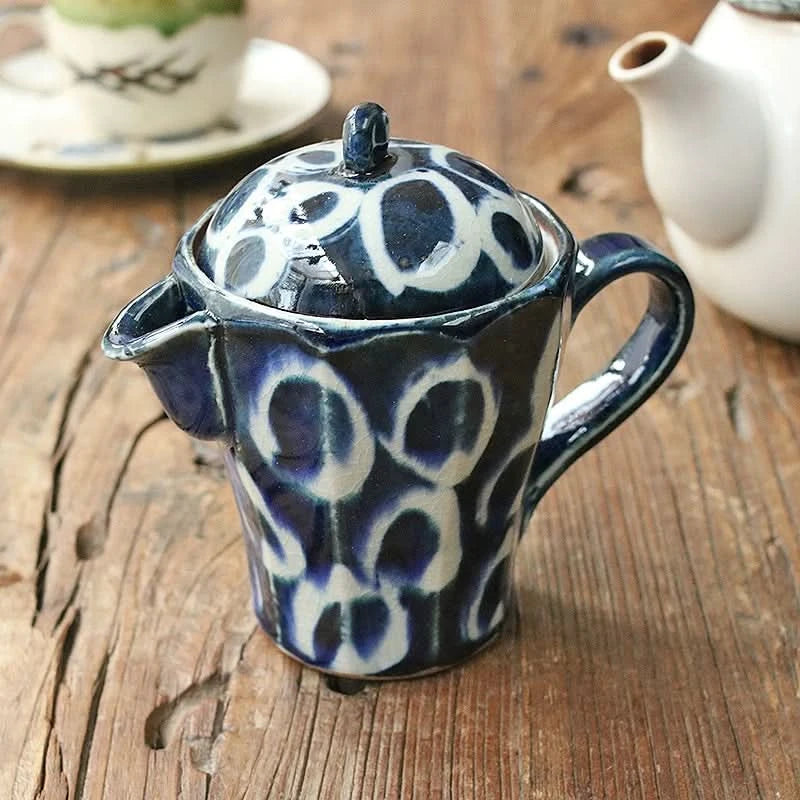 Blue & white ceramic Japanese-style dripper with hand-painted design on wood table.